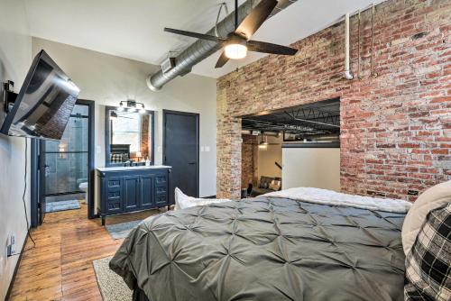 a bedroom with a bed and a brick wall at Sleek, Modern Loft in Downtown Springfield! in Springfield