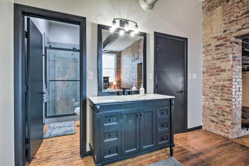 a bathroom with a sink and a mirror at Sleek, Modern Loft in Downtown Springfield! in Springfield