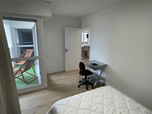 1 dormitorio con cama, escritorio y ventana en Urban flat au cœur de Lorient, en Lorient