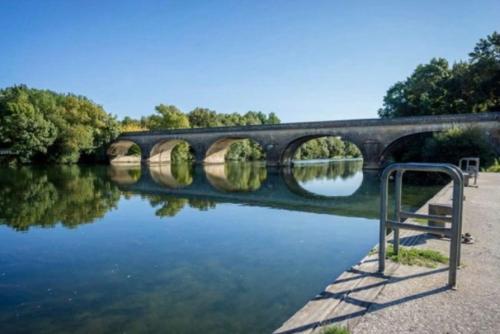 un puente sobre un cuerpo de agua con un río en Stunning bedroom overlooking the Charente en Bourg-Charente