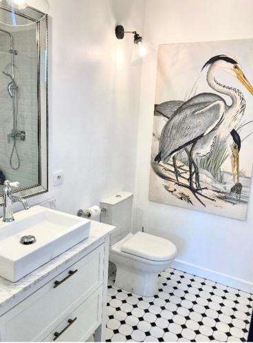 La salle de bains est pourvue d'une peinture d'oiseaux sur le mur. dans l'établissement Stunning bedroom overlooking the Charente, à Bourg-Charente