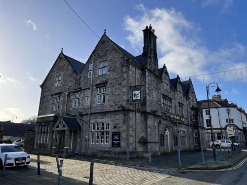 an old stone building on the corner of a street at The Bull Hotel in Llangefni