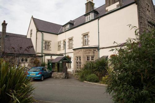 a blue car parked in front of a building at The Bull Hotel in Llangefni