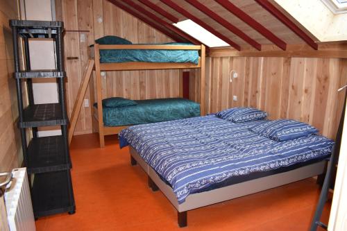 a bedroom with a bed and two bunk beds at Gîte de Montagne "Les Ecorces" in La Bresse