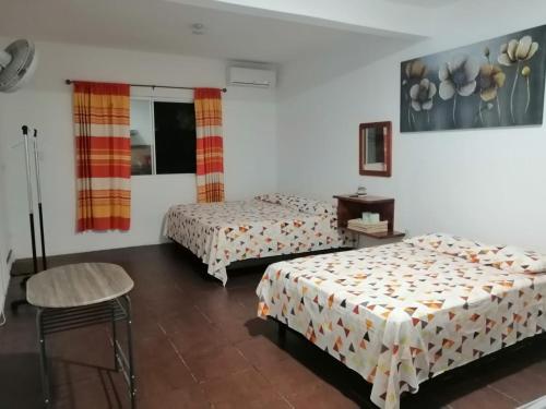 Habitación de hotel con 2 camas y mesa en Casa shambieda en Santa Cruz - Huatulco