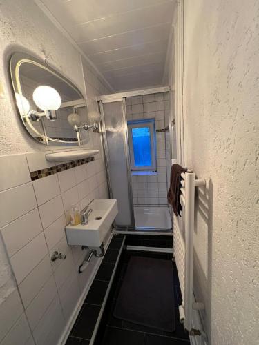 a small bathroom with a sink and a mirror at Adam's Hostel - Self Check-In & Only Private Rooms in Düsseldorf
