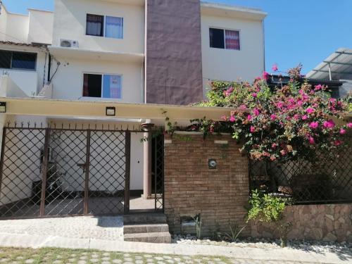 una casa con una valla y flores rosas en Casa shambieda en Santa Cruz - Huatulco