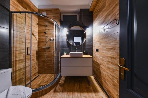 bagno con doccia, lavandino e specchio di Rex Nest a Cluj-Napoca