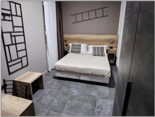 Hotel Crisvan في ريميني: غرفة نوم بسرير ابيض وطاولة ومقعد