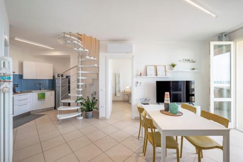 cocina y comedor con mesa y sillas en Sea view apartment en San Vincenzo