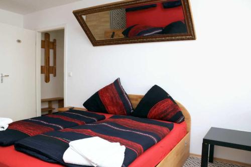 a bedroom with a red bed with a mirror on the wall at Aparthotel Kompass A 102-103 in Essen
