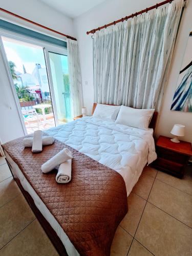um quarto com uma cama grande e uma janela grande em Villa Alkioni 31 em Paralimni
