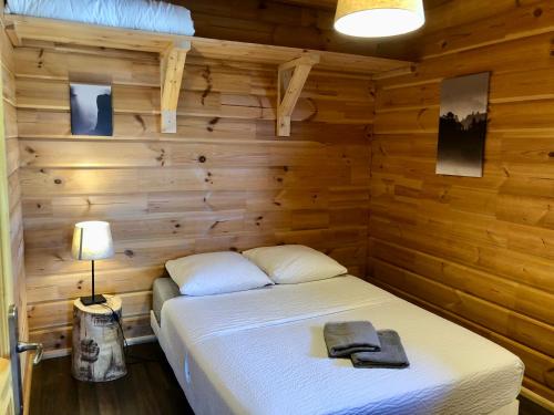 sypialnia z łóżkiem w drewnianej ścianie w obiekcie Appart 50m2 4 à 5 pers dans Chalet de charme w mieście Vimines