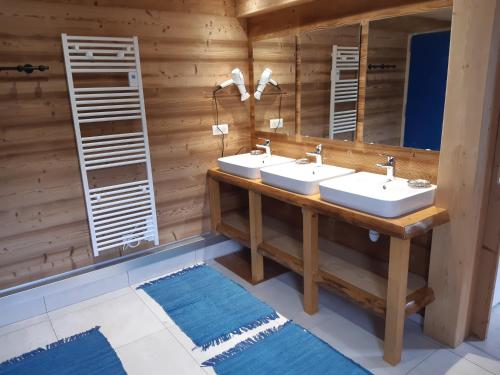 a bathroom with two sinks and a mirror at Gîte de Montagne "Les Ecorces" in La Bresse