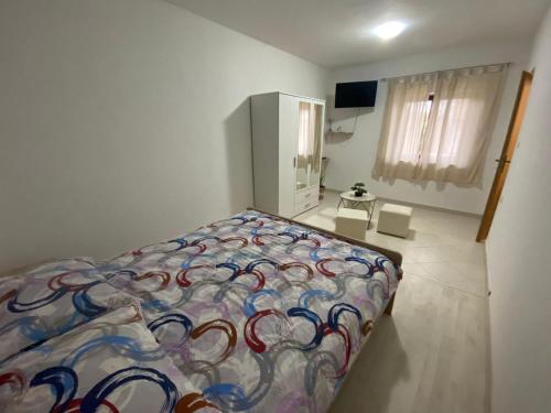 a bedroom with a bed with a colorful comforter at Apartman Nina in Posedarje