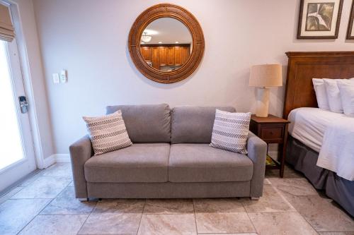 a couch in a room with a bed and a mirror at The Capri at Siesta in Siesta Key
