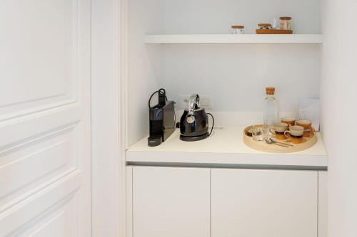 a kitchen counter with a coffee maker on a plate at APL8 St-Anna B&B in Bruges