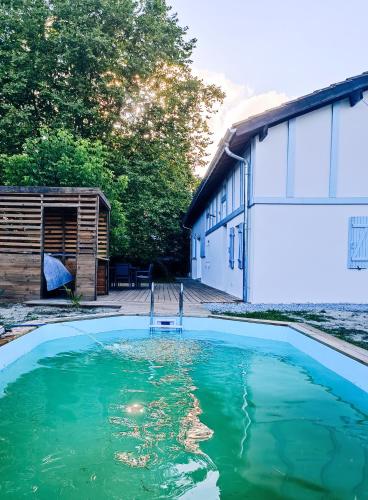 une piscine d'eau en face d'un bâtiment dans l'établissement Portets-Vieux, à Angresse