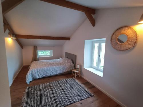 une chambre avec un lit, un miroir et une fenêtre dans l'établissement Portets-Vieux, à Angresse