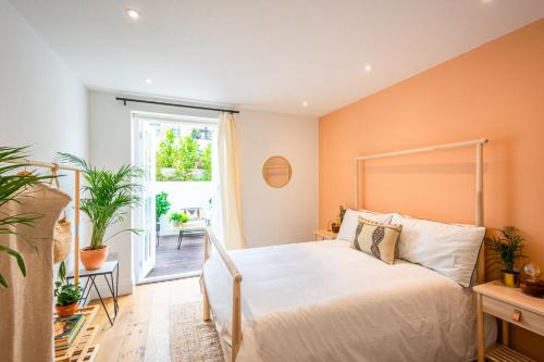 a bedroom with a bed and a large window at Be London - The De Beauvoir Residences in London