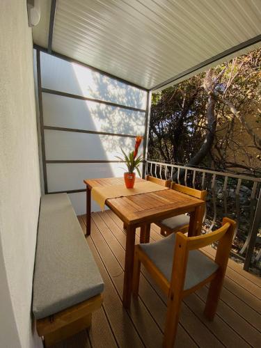 a porch with a wooden table and chairs on a balcony at Apartments Tabain in Mlini