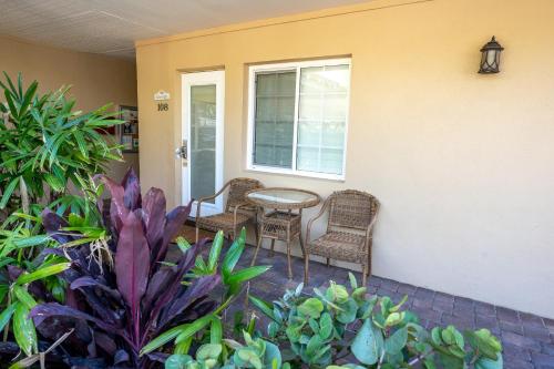 a patio with chairs and a table and some plants at The Capri at Siesta in Siesta Key