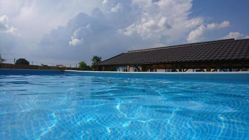 une grande piscine bleue avec un bâtiment en arrière-plan dans l'établissement La Konac, à Murighiol