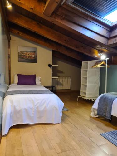 a bedroom with a large white bed and wooden ceilings at HARO EXPERIENCE Baco in Haro