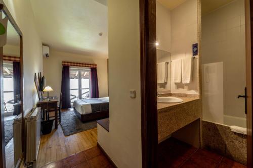 a hotel room with a bed and a bathroom at Hotel Vista Bela do Gerês in Outeiro