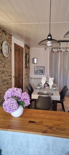 une salle à manger avec une table et des fleurs violettes dans l'établissement Maison de ville avec garage, à Prades