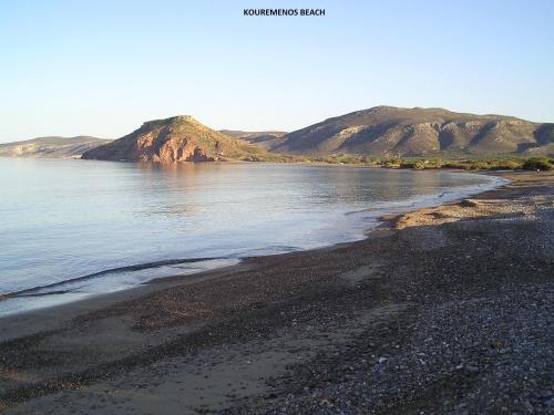 a view of a beach with mountains in the background at Kouremenos Beach Apartments in Palekastron