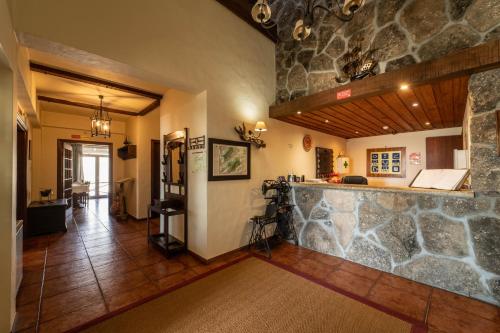 a living room with a stone wall and a counter at Hotel Vista Bela do Gerês in Outeiro