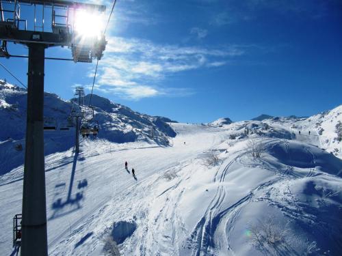 a ski lift with people skiing down a snow covered mountain at Apartments Bohinj Mavrica in Bohinj