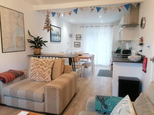 a living room with a couch and a table at Starboard Side Brixham - Ideal seaside getaway with parking in Brixham