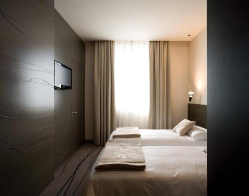 a hotel room with a bed and a television at Eos Hotel in Lecce