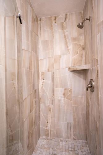 a bathroom with a shower with a tiled floor at The Capri at Siesta in Siesta Key