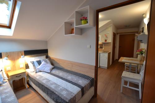 a small bedroom with a bed and a mirror at Słoneczne Apartamenty w Poddąbiu in Poddąbie