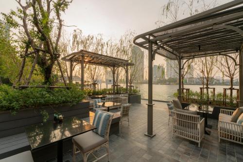 un patio con tavoli e sedie di The Salil Hotel Riverside Bangkok a Bangkok