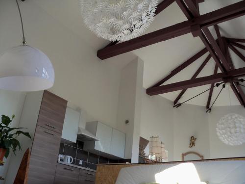 a kitchen with wooden rafters and a ceiling with beams at chateau d'eau logement insolite in Tournemire