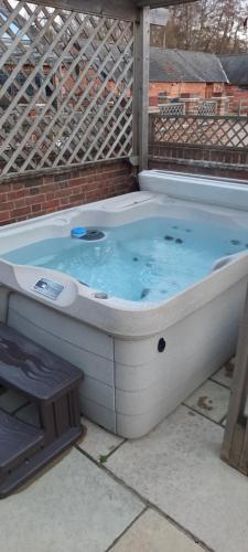 a jacuzzi tub sitting in a backyard at Blashford Manor Farmhouse - The Shetland Cottage in Ringwood