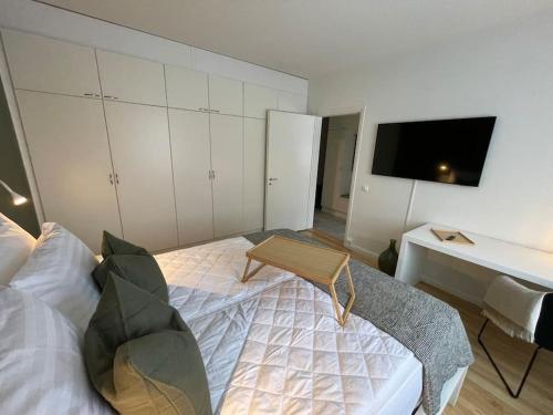 a bedroom with a bed and a desk and a tv at Hogland Apartments - 2 in Kotka