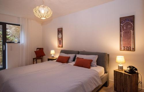 a bedroom with a large bed and a chandelier at Art of living Mosel in Longuich