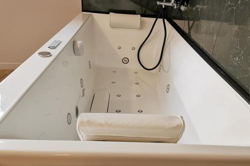 a bathtub with a bench in the middle at Appart Hotel Spa Perpignan in Perpignan