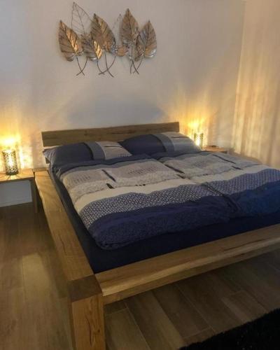 een slaapkamer met een bed met blauwe lakens en veren aan de muur bij Schöne stilvolle 45 Garten Ferienwohnung im Melchtal Kerns in Melchtal