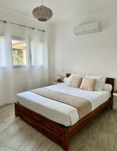 a bedroom with a large bed with white walls at Residence Casa Di Paoli in Porto-Vecchio