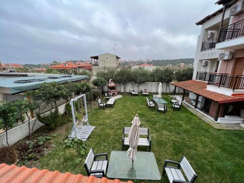 a patio with chairs and a table and umbrella at Nea Roda Apartments in Nea Roda