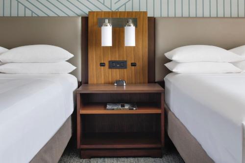 two beds in a hotel room with a nightstand between them at Minneapolis Marriott City Center in Minneapolis