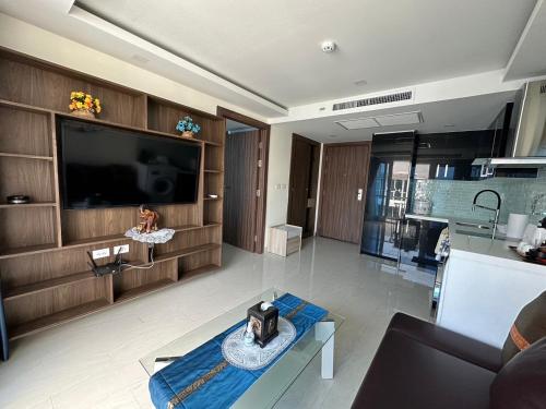 a living room with a large television and a table at Luxury Business Suits in Grand Avenue by Pattaya City Estates in Pattaya