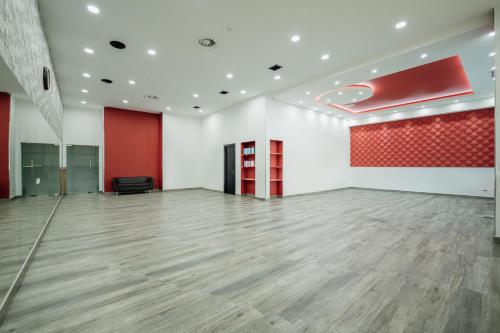 a large room with a wooden floor and a red wall at Hills Resort Hotel in Yerevan