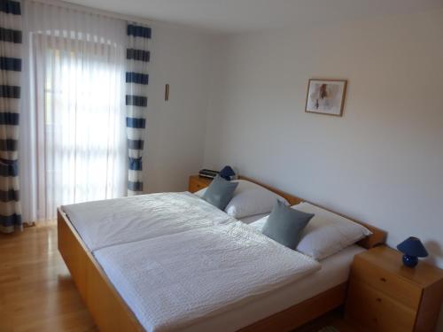 een slaapkamer met een groot bed met blauwe kussens bij Ferienwohnungen Reitinger in Tiefenbach
